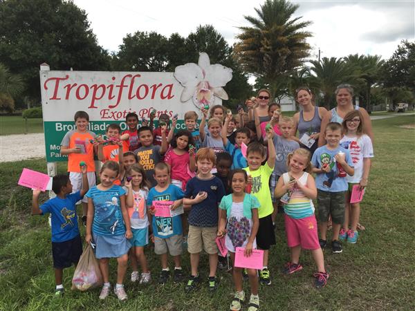 students pose for picture in front of Tropiflora sign